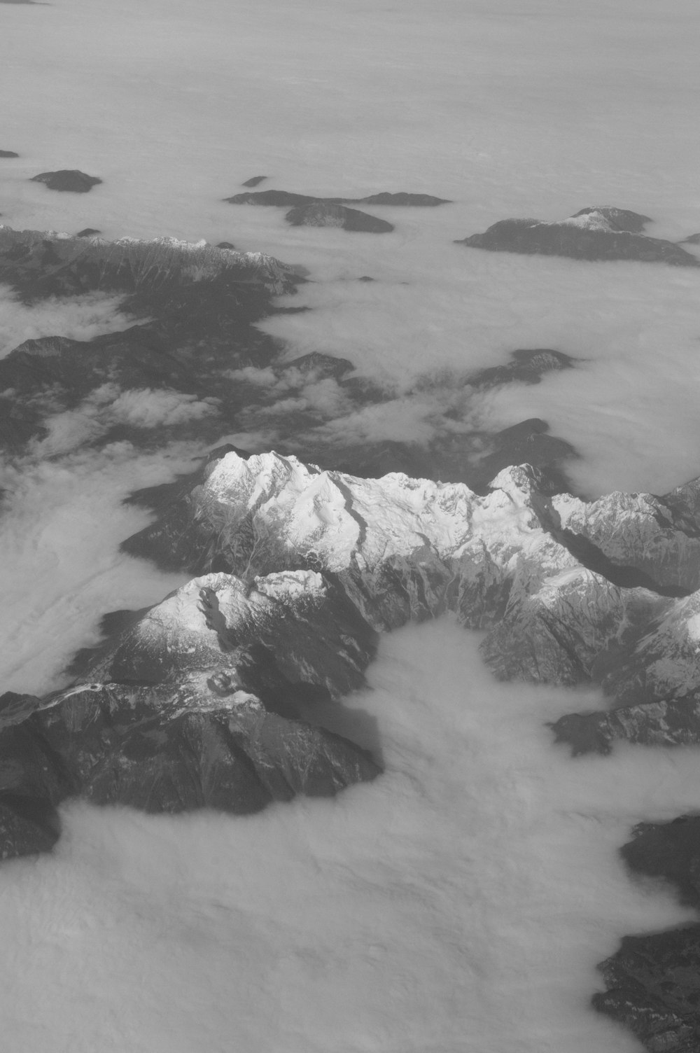 a black and white photo of snow covered mountains