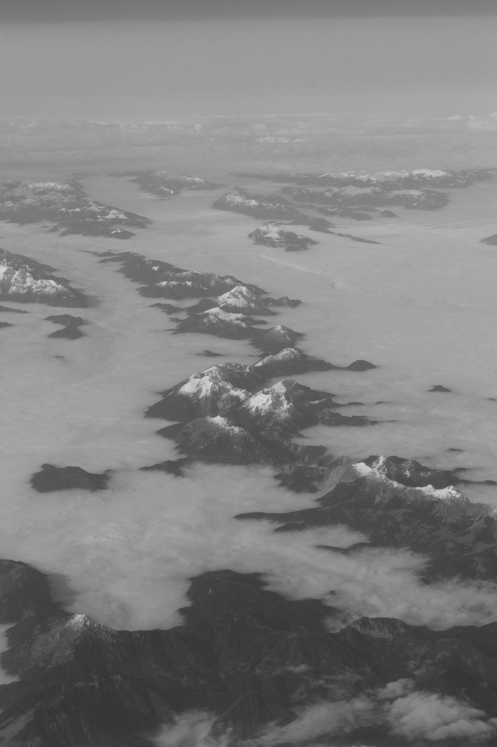 a black and white photo of mountains and clouds