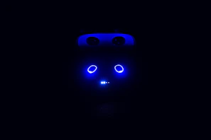 A close-up shot of a robot-themed t-shirt sleeve showing the same bold font as the homepage in electric blue