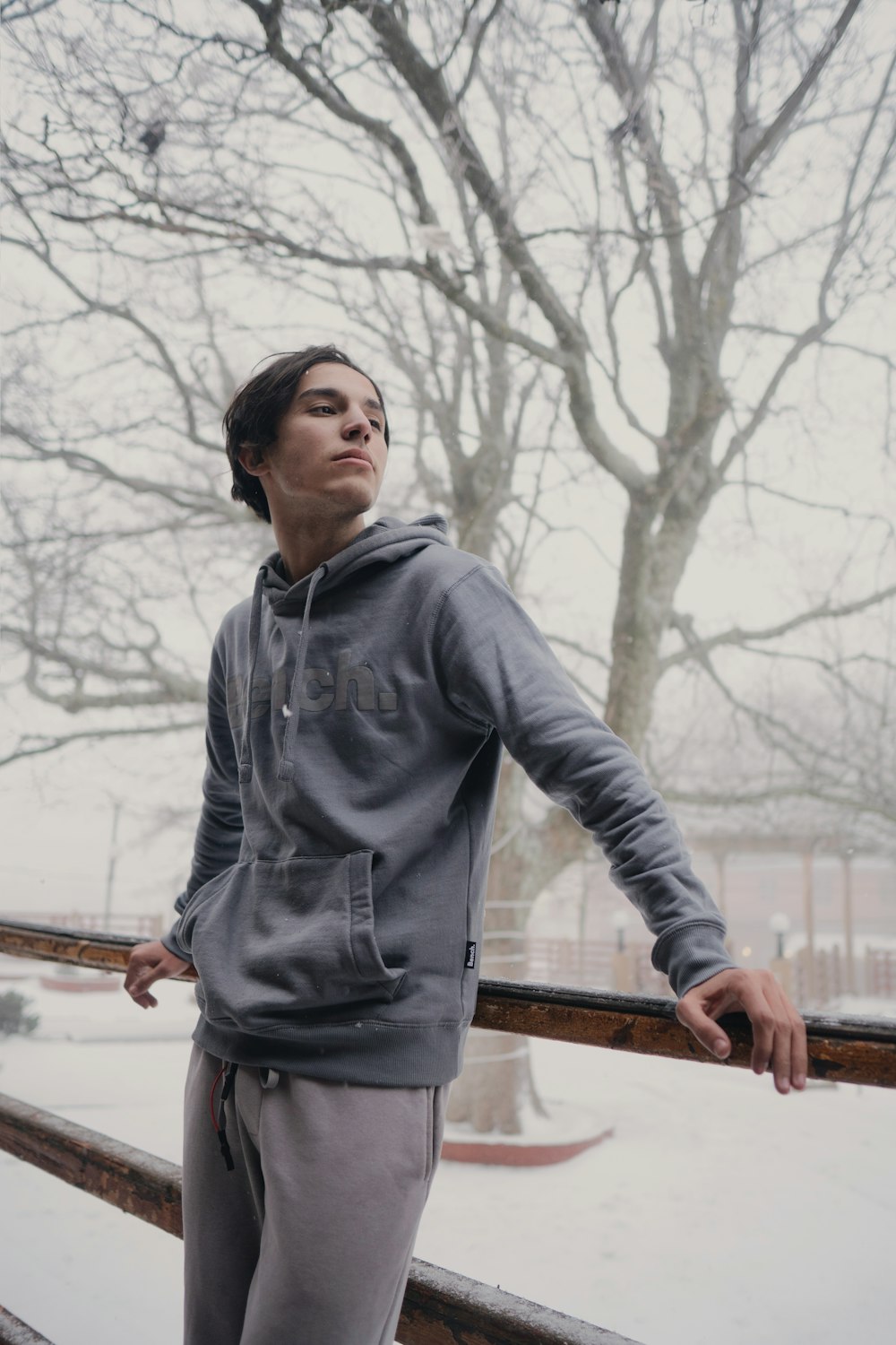 a young man standing on a deck in the snow