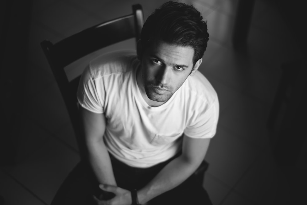 a black and white photo of a man sitting in a chair