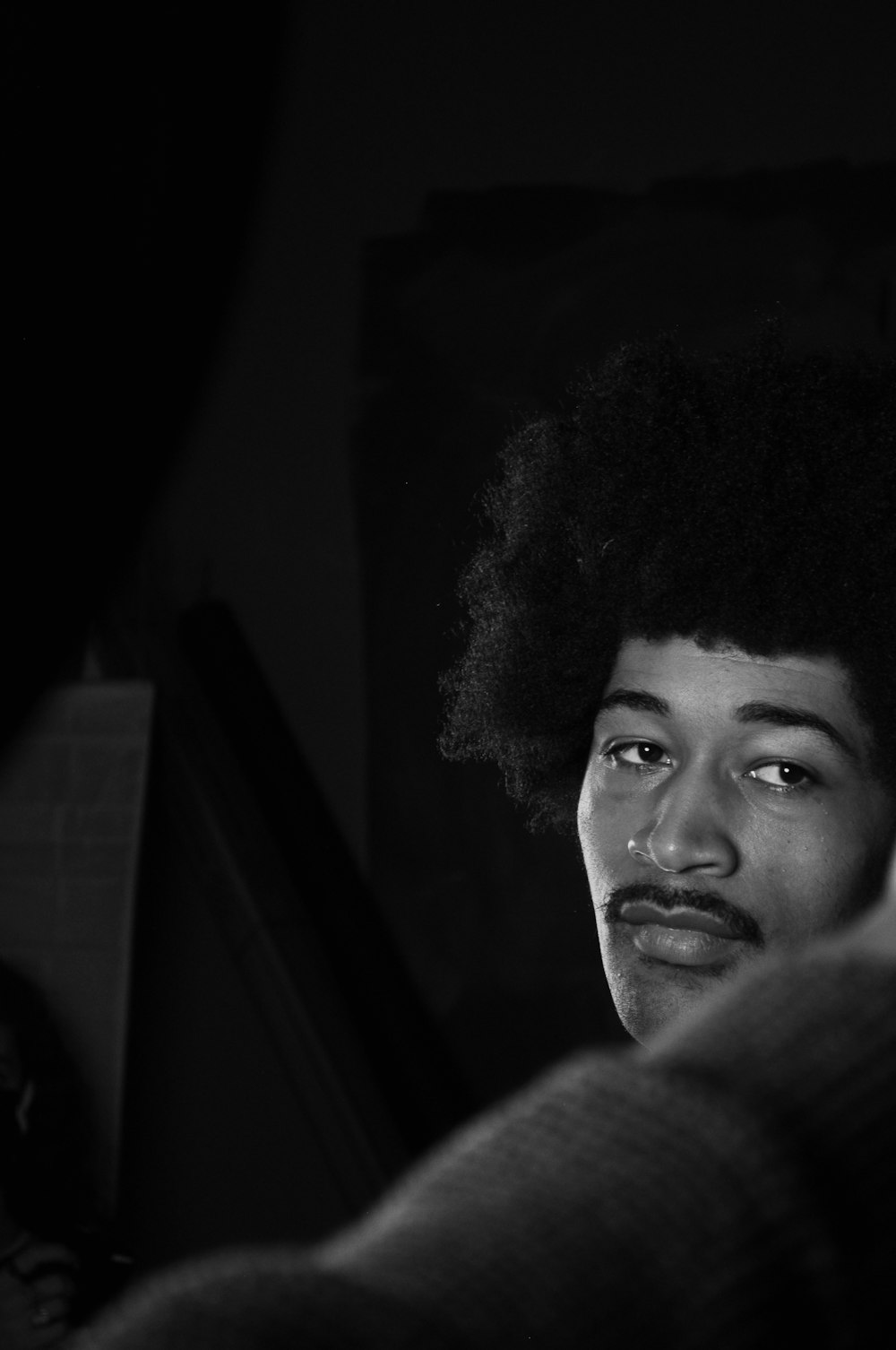 a black and white photo of a man with an afro