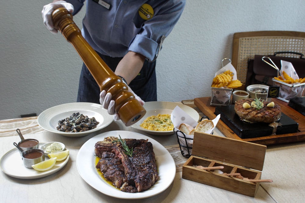 a person pouring sauce on a plate of food