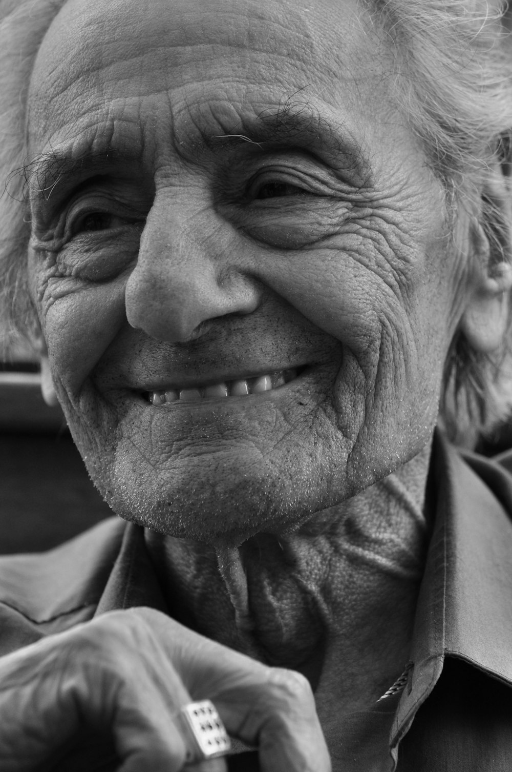 a black and white photo of an old woman smiling