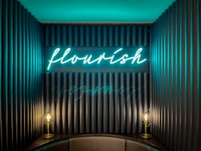 A cozy workspace with neon signs glowing softly on the walls.