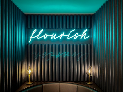 A cozy workspace with neon signs glowing softly on the walls.