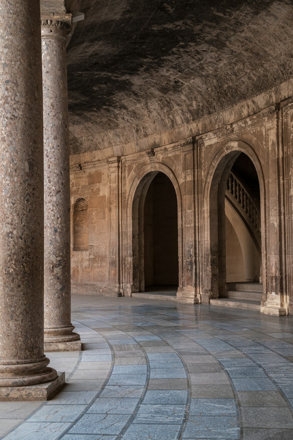 a large room with many pillars and a clock on the wall