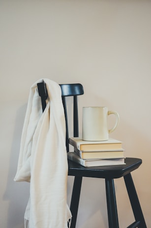 A cozy striped scarf draped over a wooden chair.