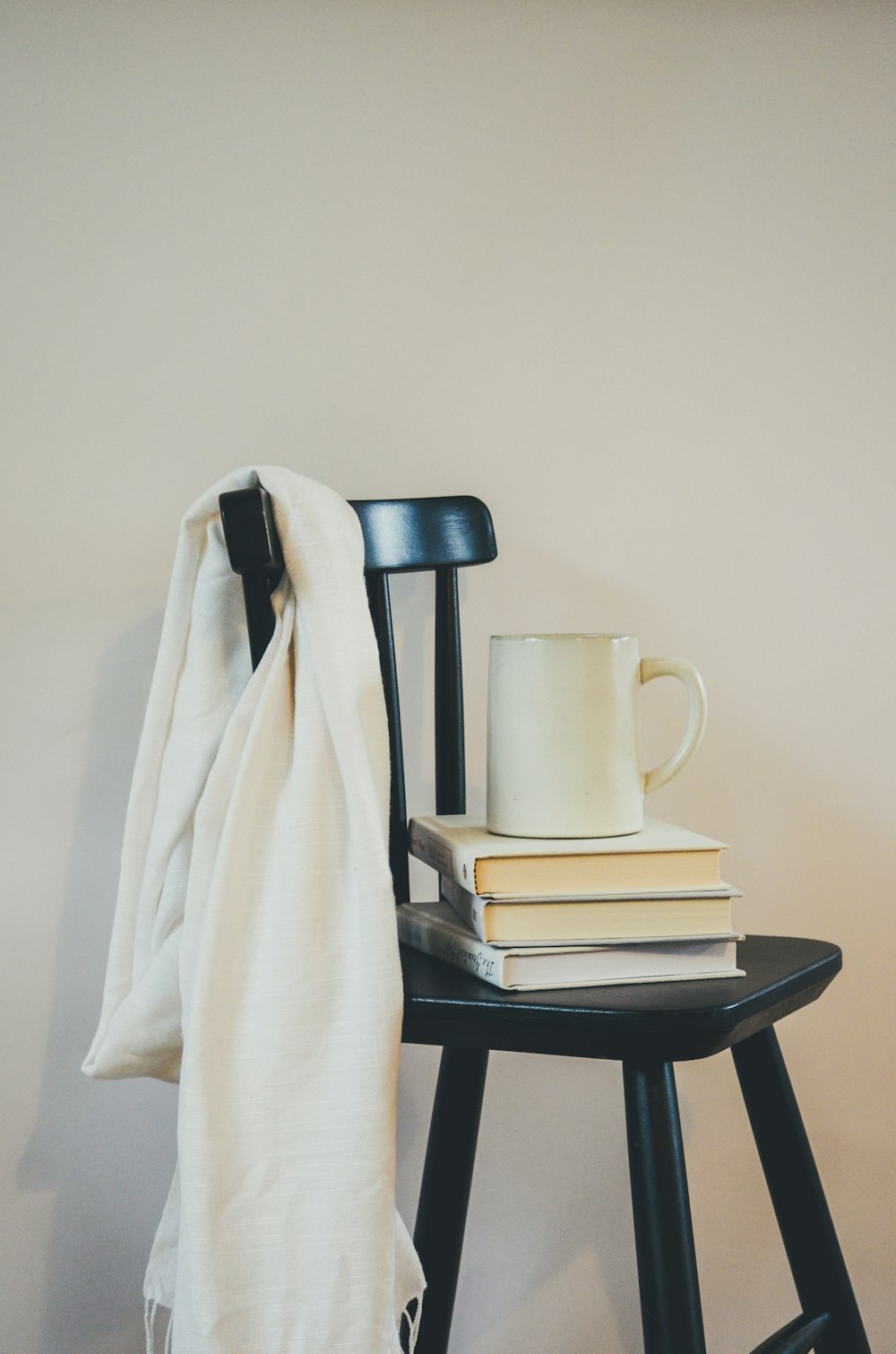 a stack of books sitting on top of a wooden chair