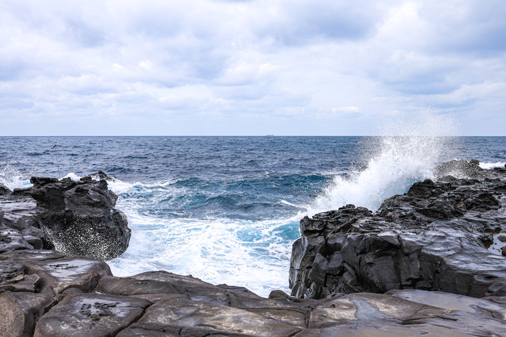 a rocky shore with waves crashing against the rocks