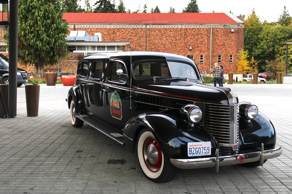 an old black car is parked on the street