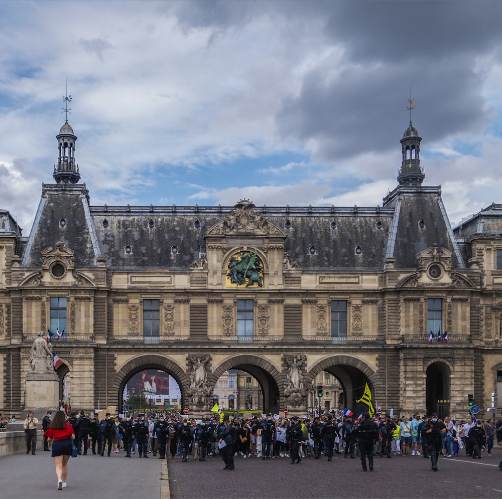 a group of people standing in front of a large building