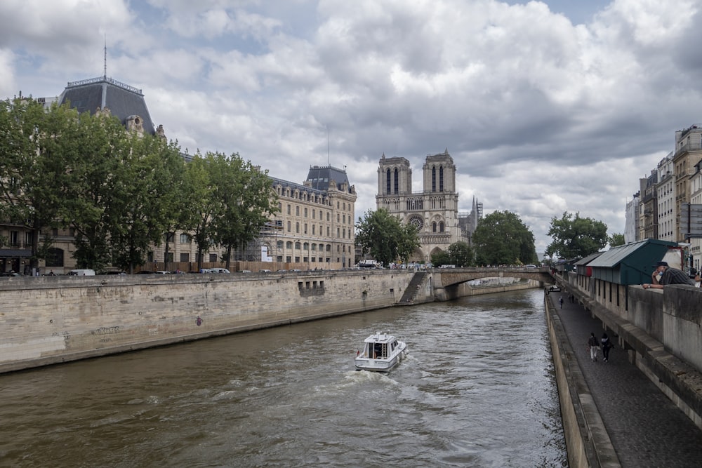 a boat traveling down a river next to tall buildings