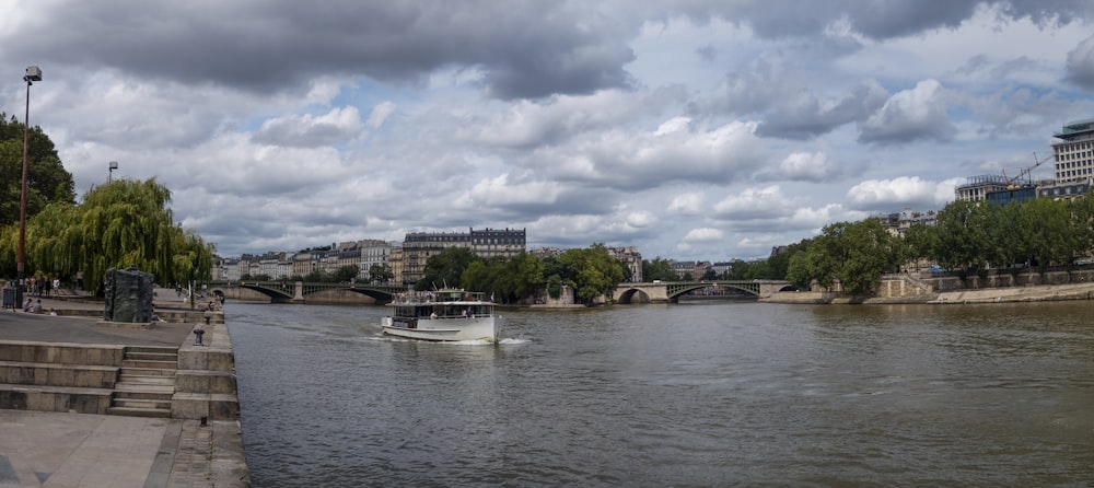 a boat traveling down a river next to a bridge