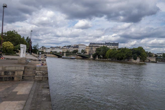 Visitors enjoying a peaceful walk along the Seine with Monet-inspired landscapes in the background.