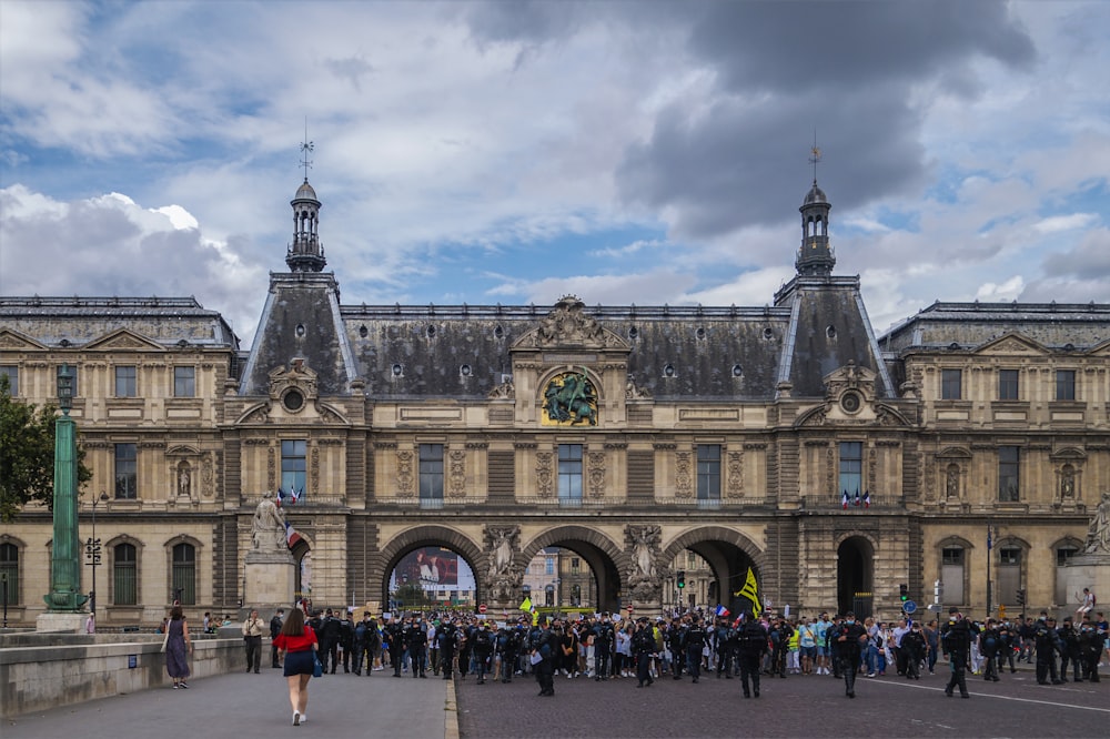 a group of people standing in front of a large building