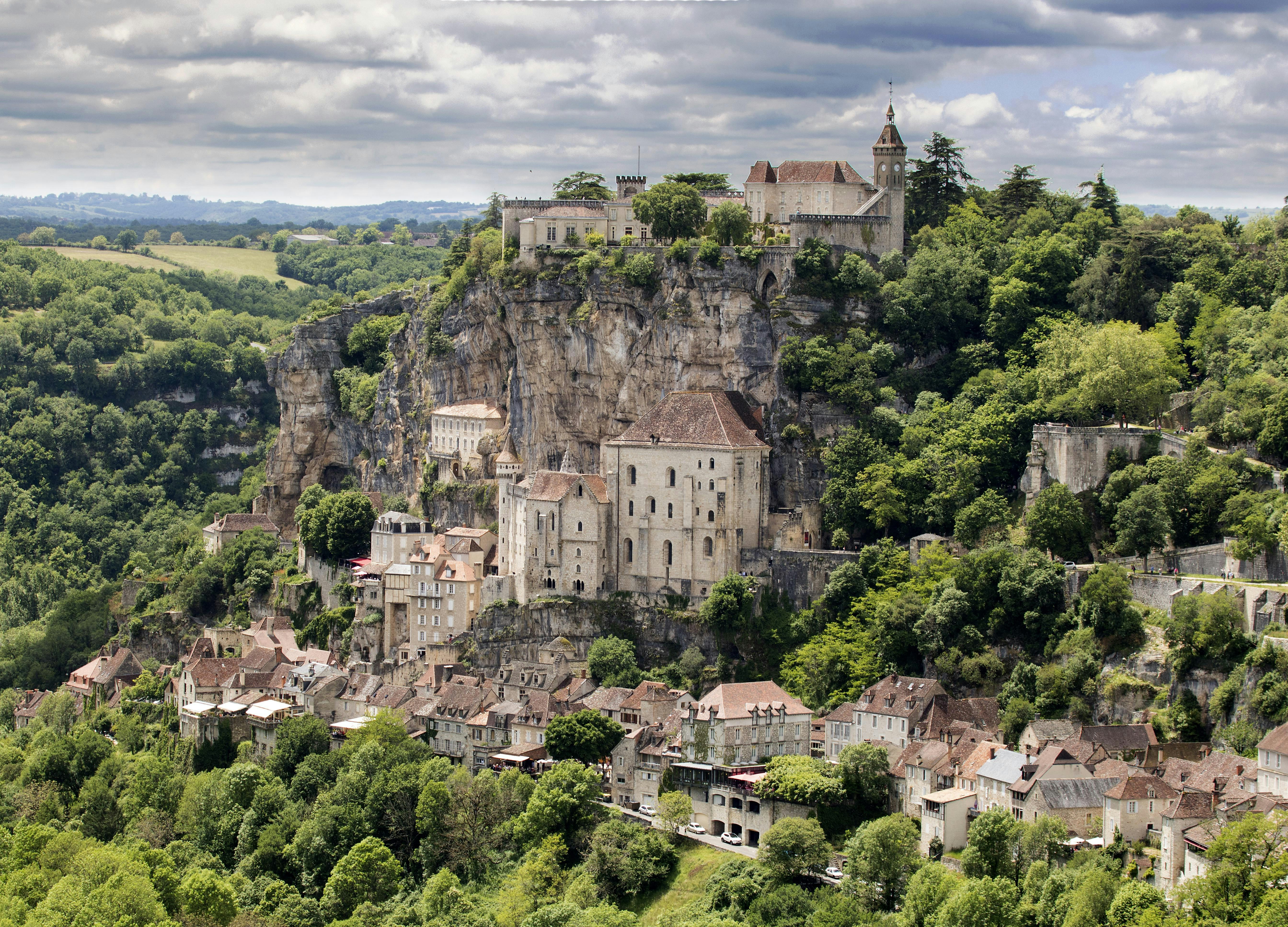 a village on a hill surrounded by trees