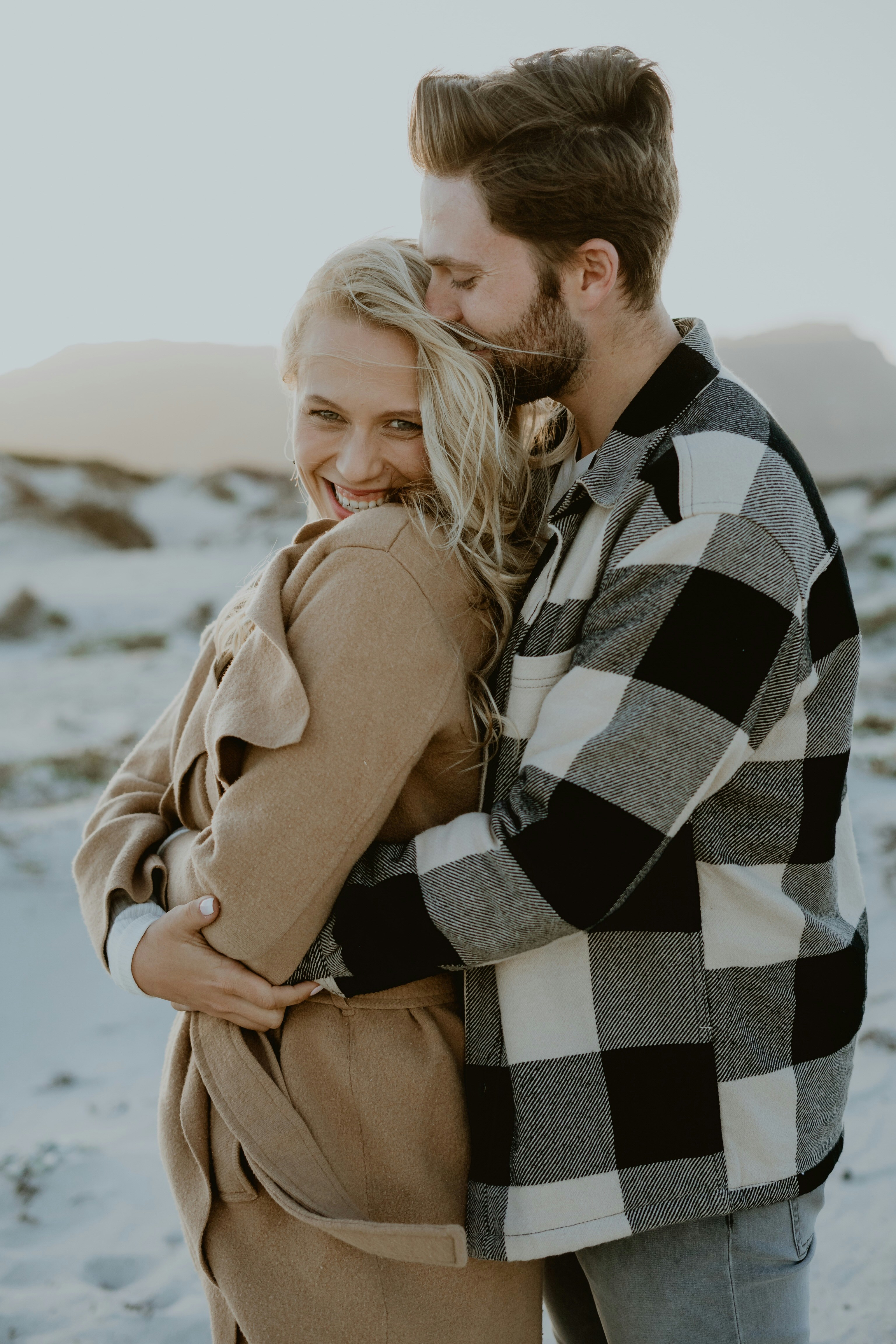 a man and a woman hugging each other in the snow