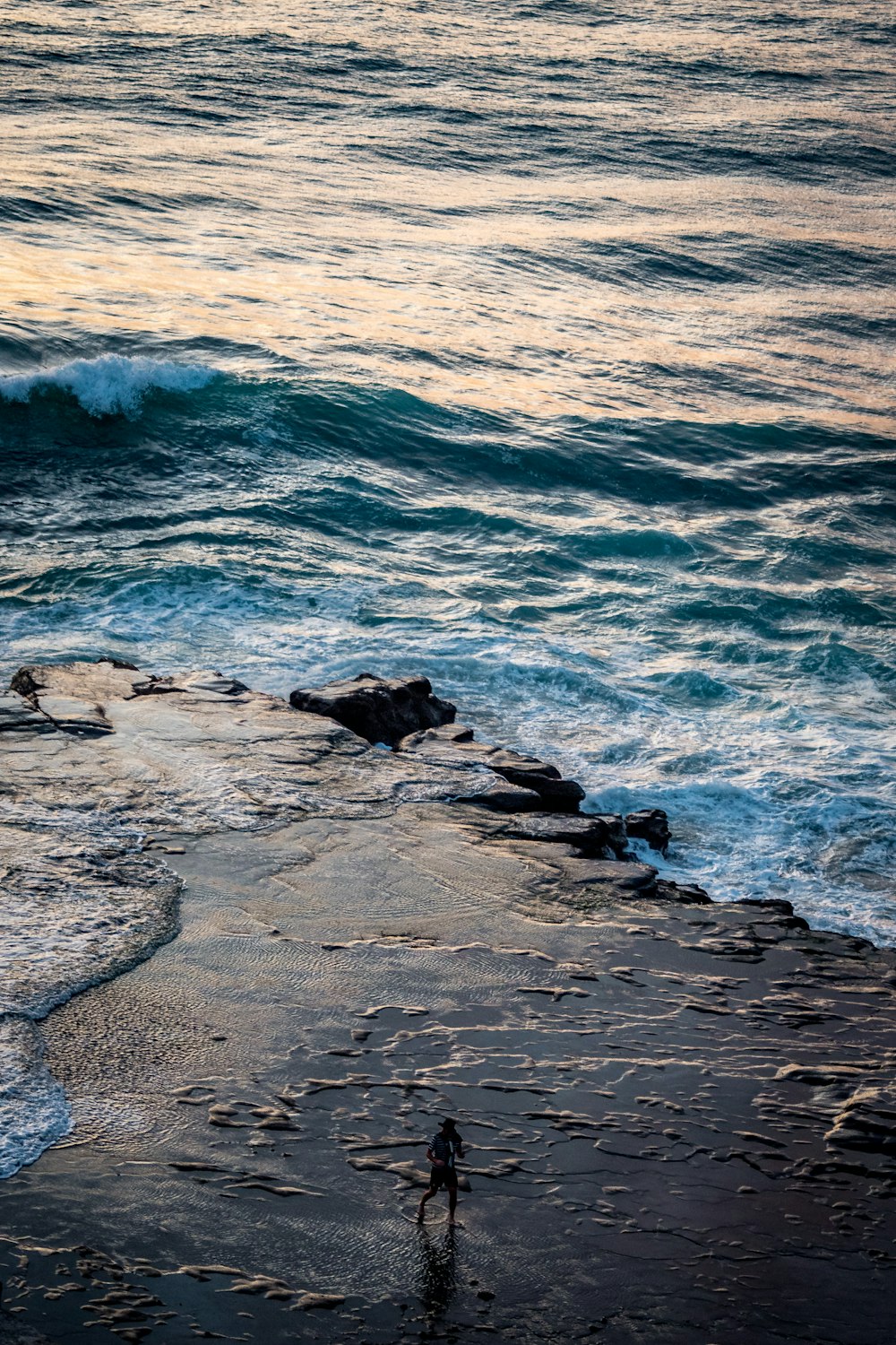 a person standing on a beach next to the ocean