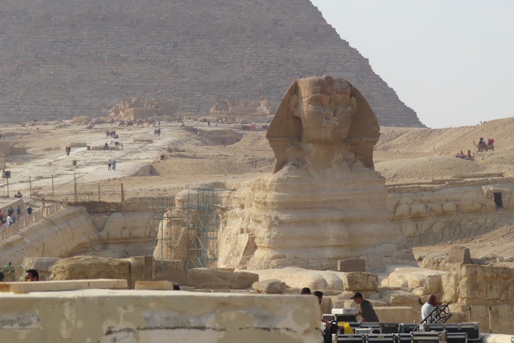 a group of people standing in front of a large sphinx