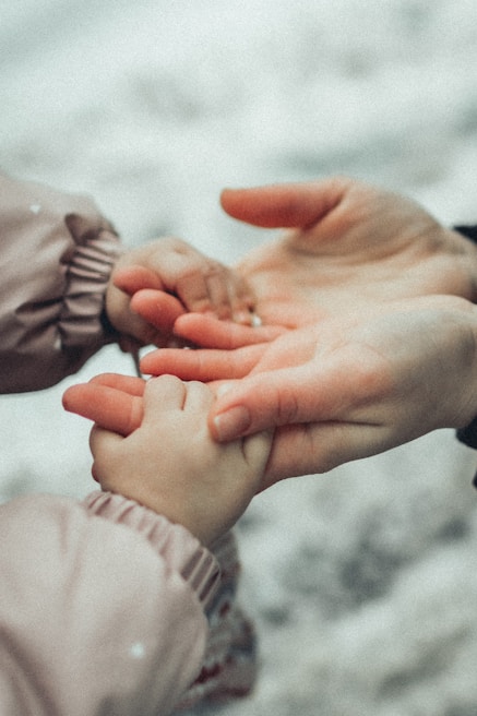 Close-up of compassionate hands gently holding a patient's hand during a consultation