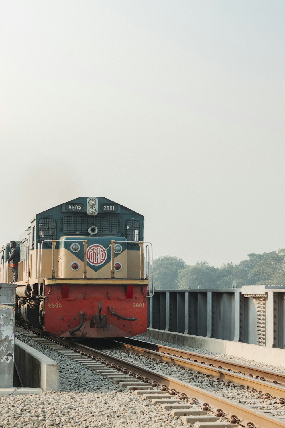 a train traveling down train tracks next to a forest