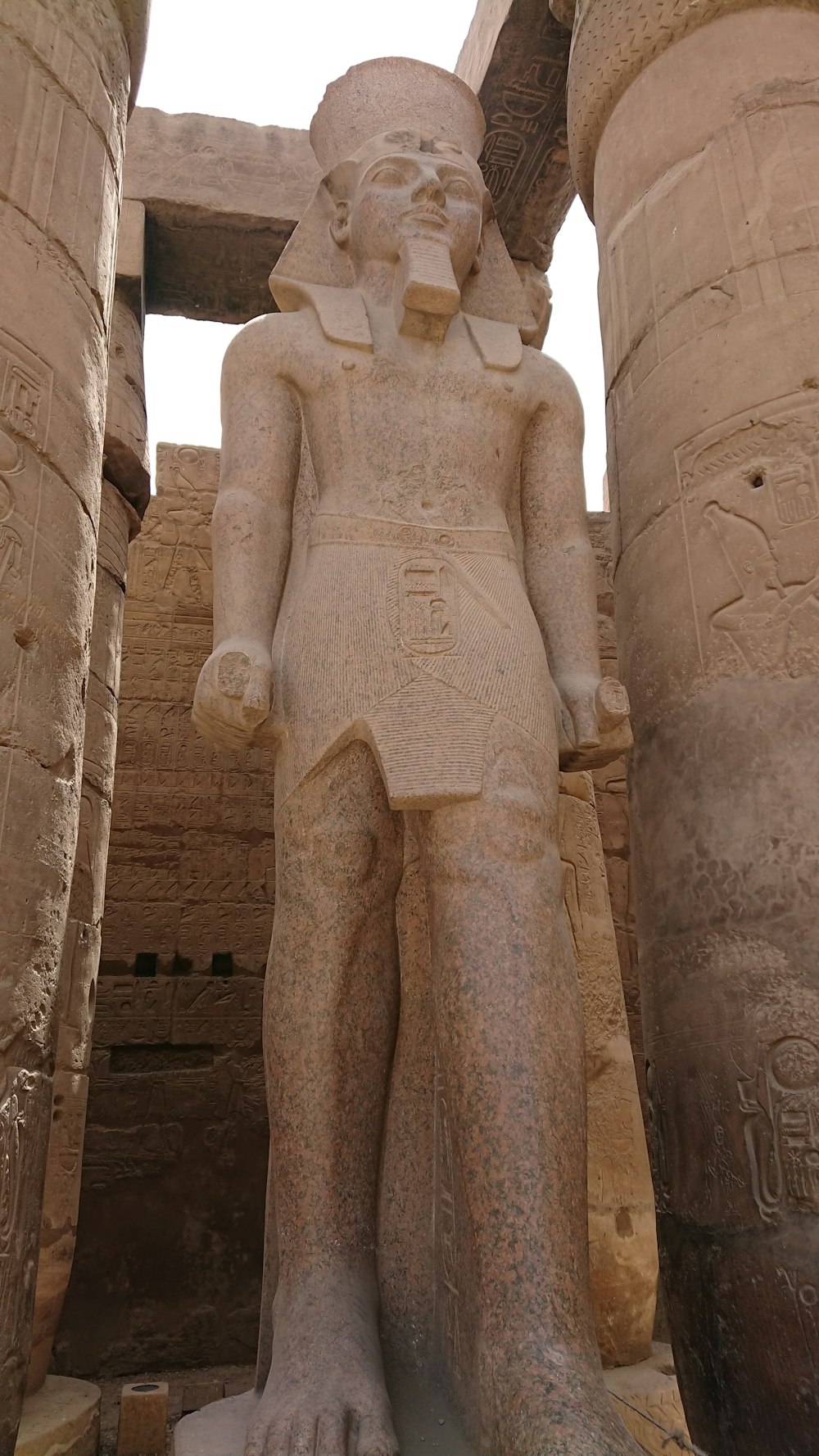 a statue of a man standing next to two large pillars