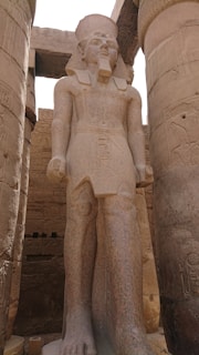 a statue of a man standing next to two large pillars