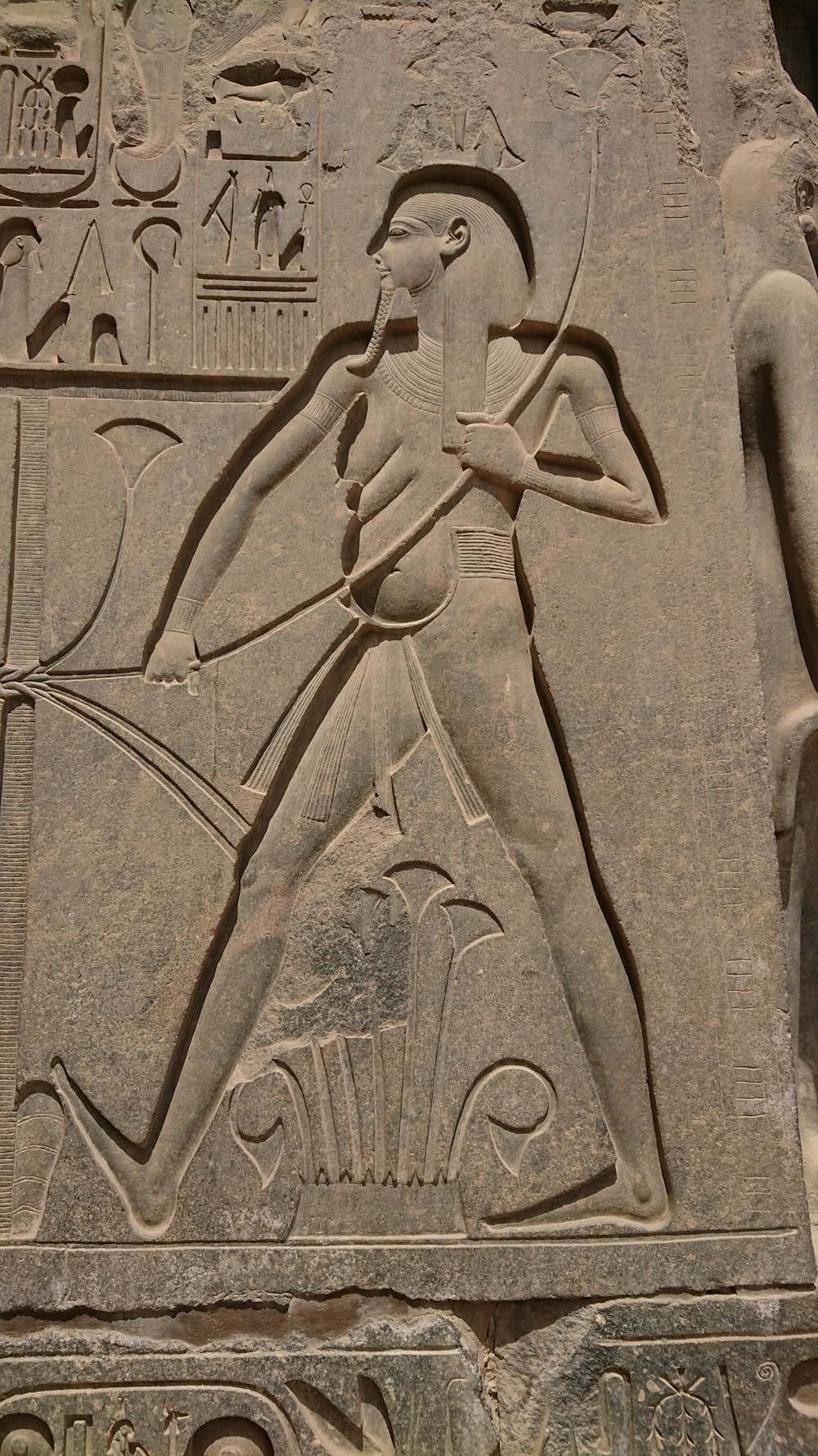 a stone carving of a man with a bow and arrow