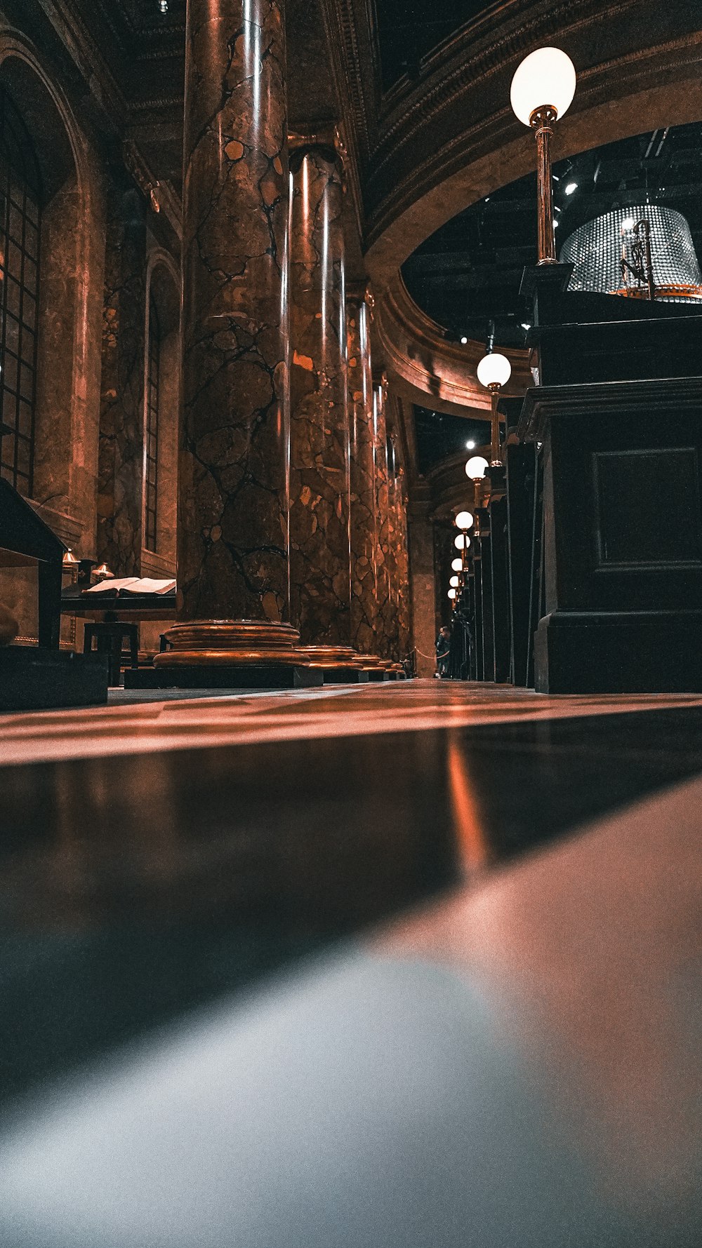 a dimly lit room with benches and a chandelier