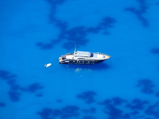 a small yacht floating on top of a blue ocean