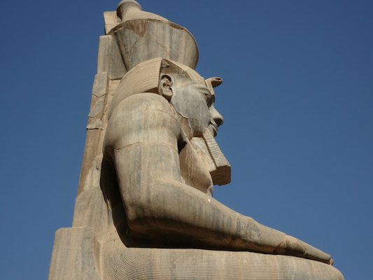 A statue of an egyptian god with his head in his hands — Luxor, Egypt