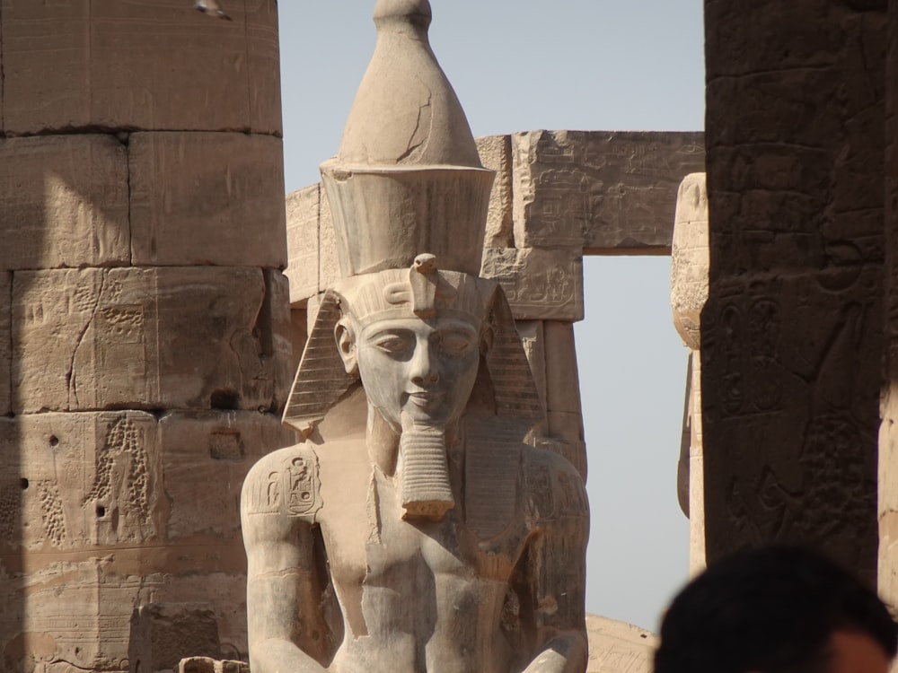 Eine Statue eines ägyptischen Gottes vor einem Gebäude