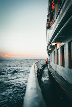Sunset view from the deck of a cruise ship with calm ocean waves.