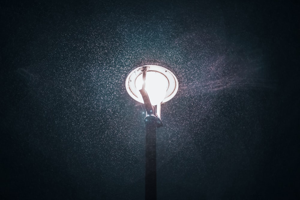 a street light in the dark with snow on it