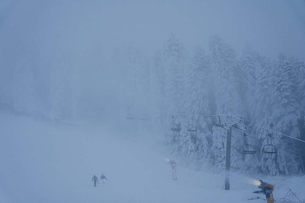 a snow covered ski slope with a ski lift in the background