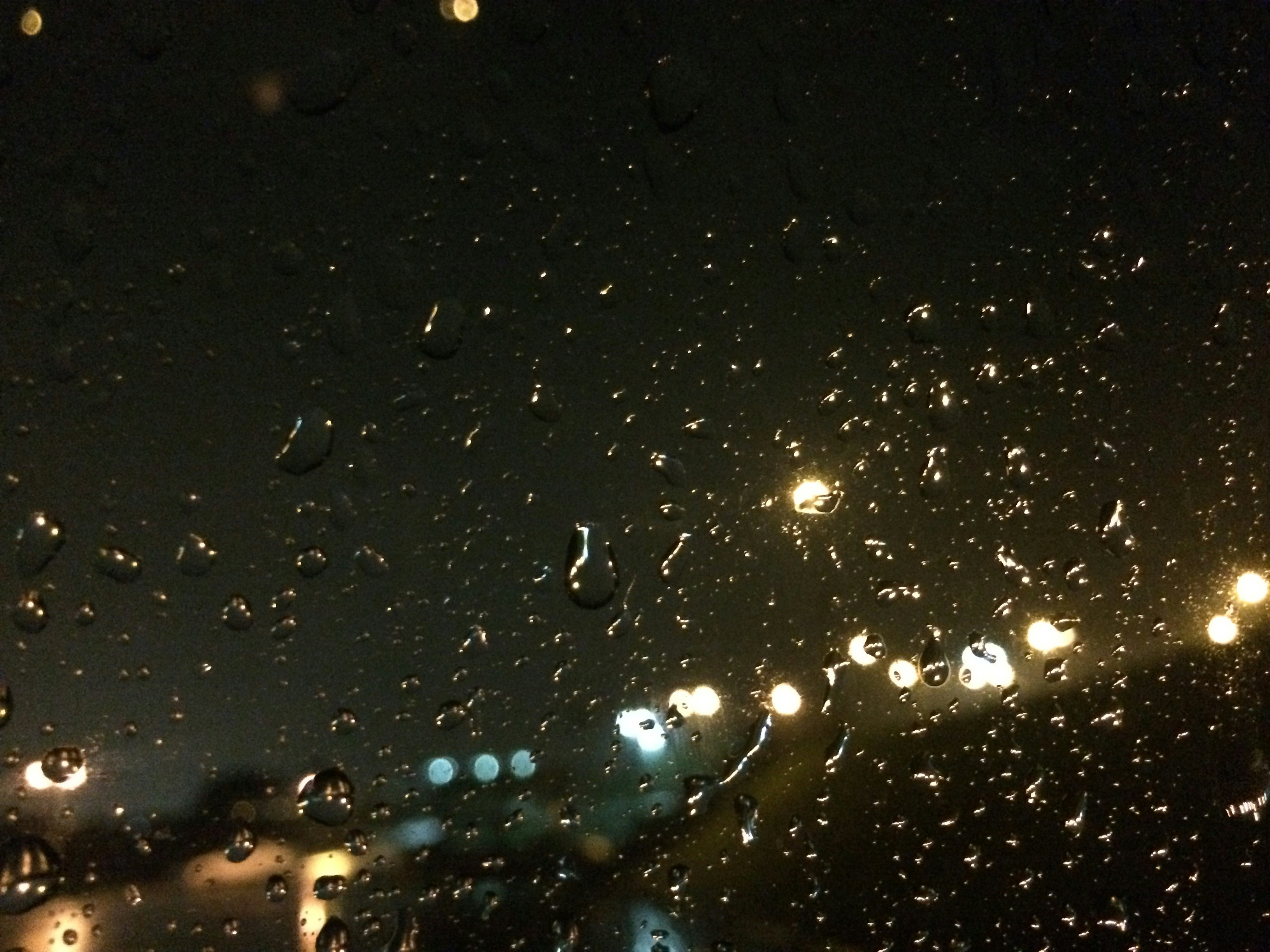 rain drops on the window of a car at night