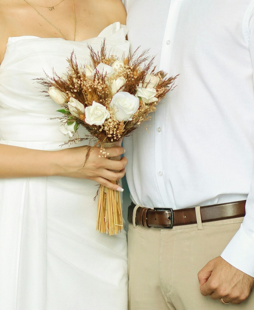 a bride and groom holding a bouquet of flowers