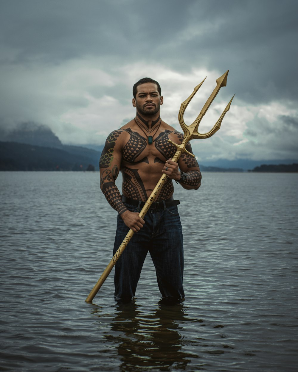a man standing in the water holding a large stick