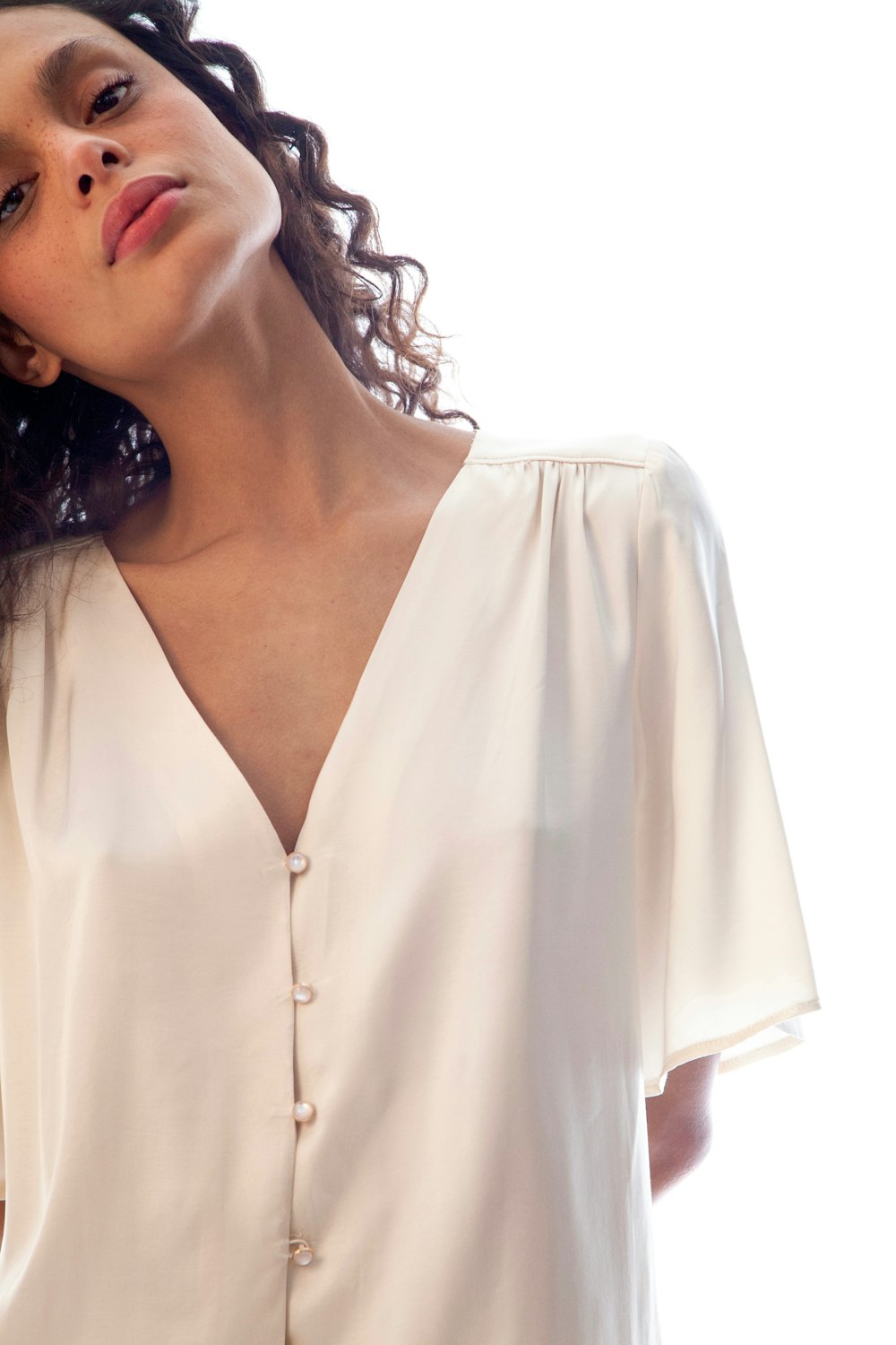 a woman with curly hair wearing a white blouse