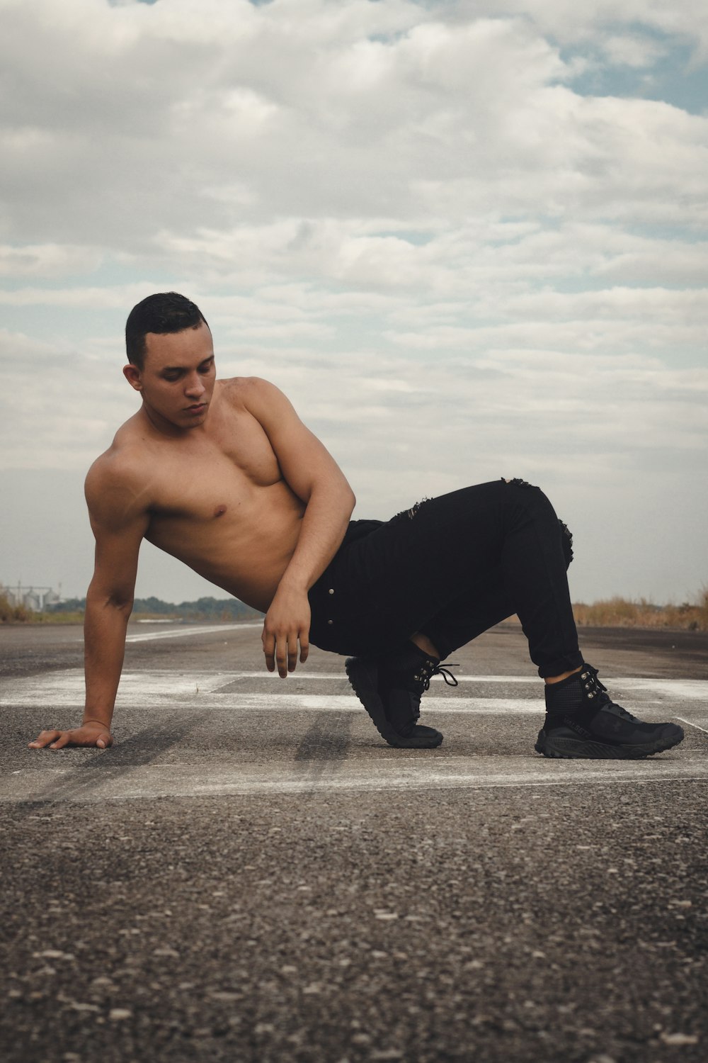 a shirtless man leaning over on a runway