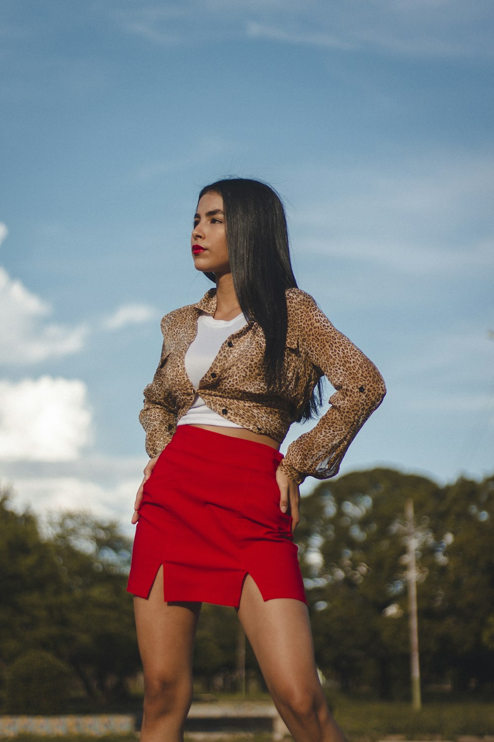 a woman in a red skirt is posing for a picture