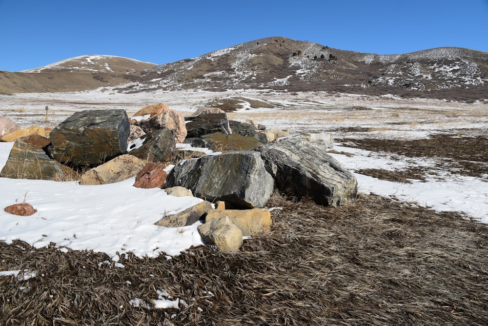 a pile of rocks sitting on top of a snow covered field