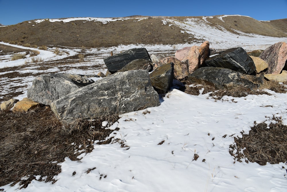 a pile of rocks sitting on top of a snow covered ground