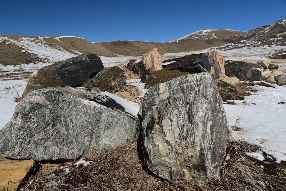 a group of rocks sitting on top of a snow covered ground