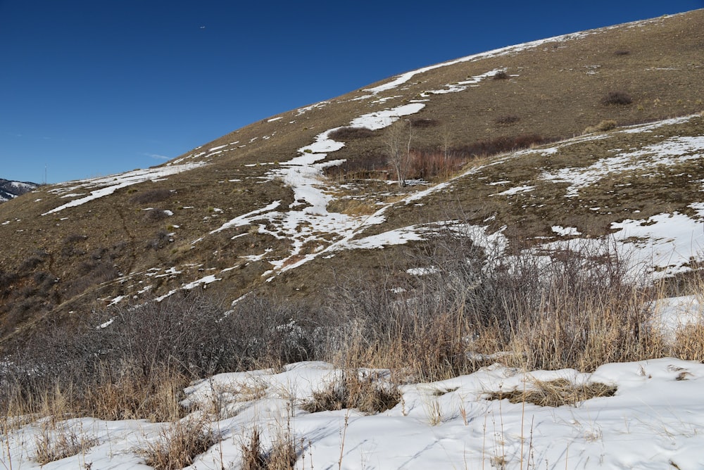 a snow covered hill with a snow covered hill in the background