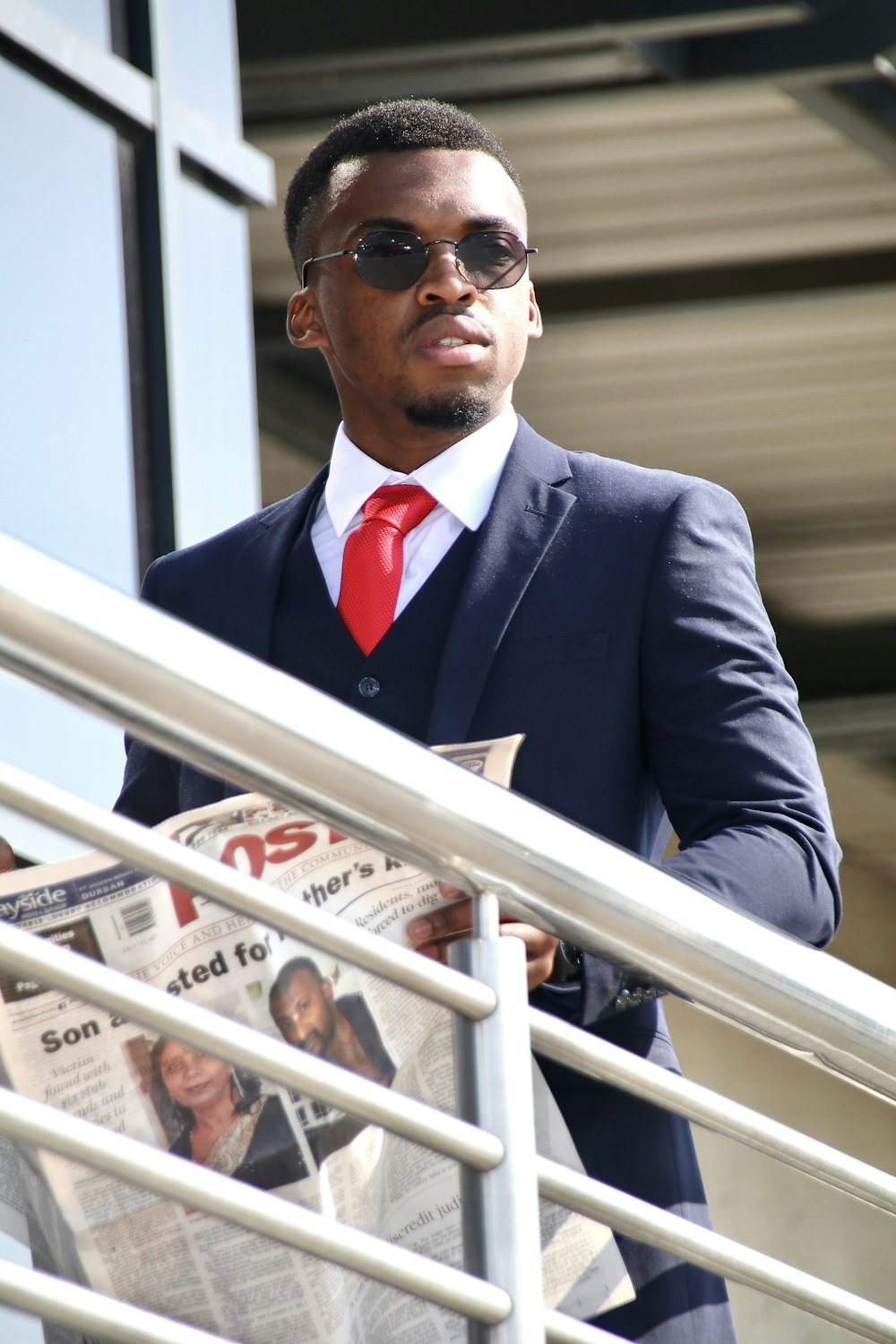 a man in a suit and tie reading a newspaper