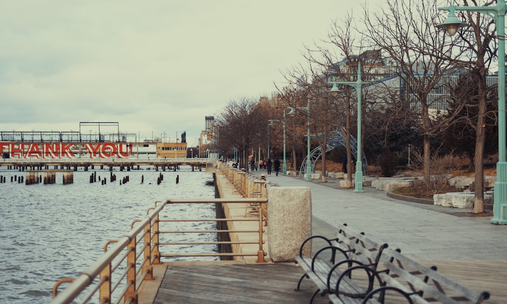 a bench sitting on the side of a river next to a pier