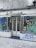A storefront with graffiti-covered windows and doors, featuring various abstract designs and doodles in multiple colors. The sign above the store reads 'A Deusa'. The ground is covered in cobblestone pavement.