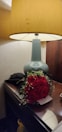 Nightstand with a reading lamp and a small vase of fresh flowers.